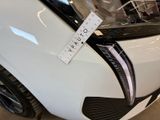 a close up of a white car with a sticker on it ' s hood