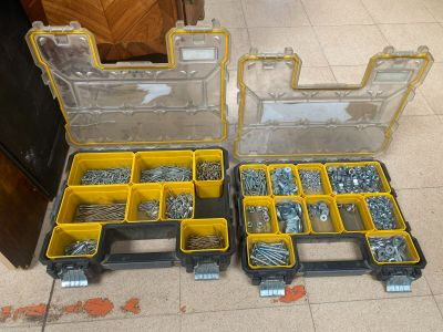 two yellow boxes filled with screws and nuts on the floor