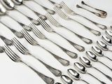 de nombreuses fourchettes et cuillères disposées sur la table