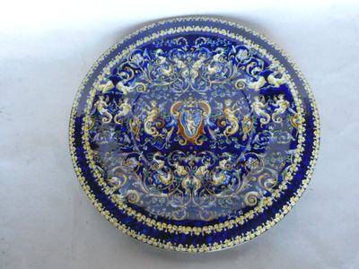 une assiette bleue et dorée sur laquelle est représenté un oiseau
