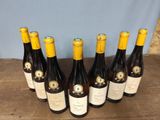 six bottles of wine are lined up in a row on a table