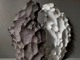 des sculptures en béton sont posées sur une table devant un mur gris