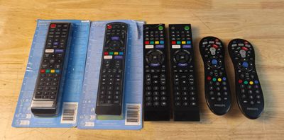 quatre télécommandes sont posées les unes à côté des autres sur une table