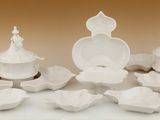 beaucoup d'assiettes et de bols blancs sur la table