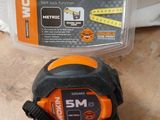 the measuring tape is next to a measuring tape in a plastic case