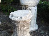 two cement urns sitting next to each other on the ground