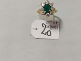 Gros plan sur une bague ornée d'une pierre verte