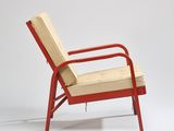an image of a red chair with a beige cushion on it