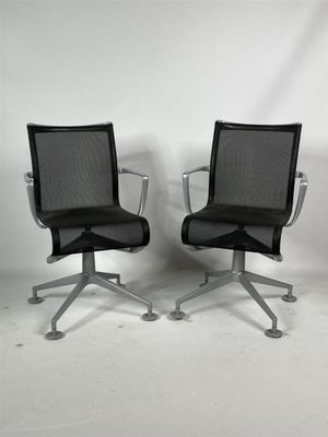 deux chaises de bureau noires placées l'une à côté de l'autre sur un sol blanc