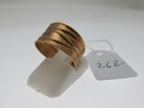 une bague en or avec une étiquette de prix posée sur une surface blanche