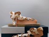 pair of women ' s tan leather sandals with laces on them