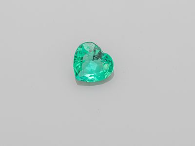 a heart shaped emerald gems on a white background