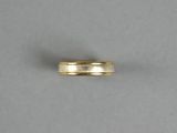 a close up of a gold wedding ring on a white surface