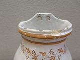 a white vase with gold designs on it on a table