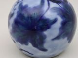 un vase bleu et blanc posé sur une surface blanche
