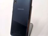 the back of a black samsung phone sitting on top of a metal stand