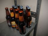 several bottles of beer are lined up on a shelf in a room