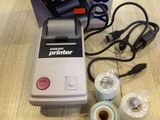 a small printer sitting on top of a table next to a box
