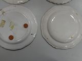 three white plates with orange dots on them sitting on a table