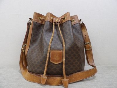 a close up of a brown and brown bucket bag on a white surface