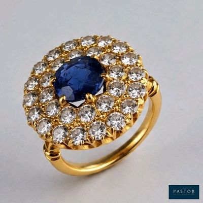 gros plan d'une bague avec une pierre bleue entourée de diamants blancs
