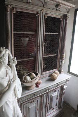 a statue of a woman holding a basket on top of a cabinet