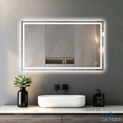 un lavabo blanc placé sous un grand miroir dans une salle de bains