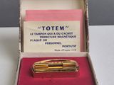 une petite boîte contenant un stylo de couleur dorée