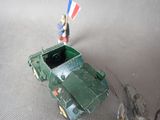 a toy soldier standing next to a toy army vehicle