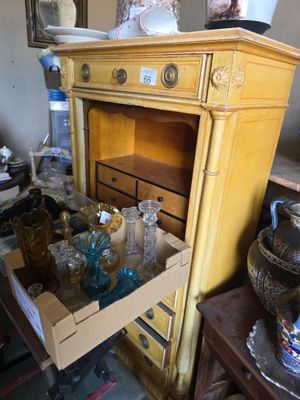 une commode dont un tiroir est rempli de vases
