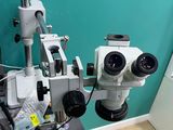 two microscopes sitting on a table in a room