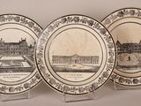 three plates with a picture of a castle on them on a table