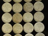 some silver coins are arranged in a square on a black surface