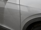 a close up of a car ' s side door with a reflection of a person in the window