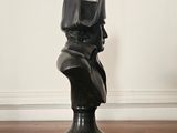 a black bust of a cat on a wooden floor
