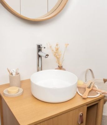 a white sink sitting on top of a wooden vanity