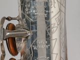 a close up of a silver saxophone on a table