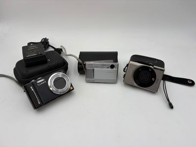 three cameras sitting next to each other on a table