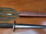 two knives and a spatula on a wooden table