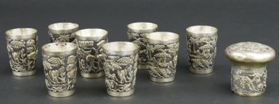 six verres à shot en argent posés les uns à côté des autres sur une table