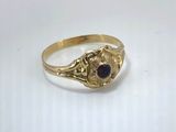 a close up of a gold ring with a red stone in the center