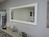 un miroir accroché au mur au-dessus d'une commode dans une pièce
