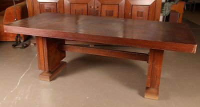 a large wooden table in a room with wooden chairs