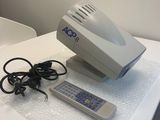 une table blanche sur laquelle se trouvent une télécommande et un ordinateur