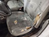 a dirty seat in the back of a car that has been vandalized