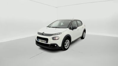 Une Citroën blanche est garée dans une pièce blanche