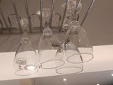 many wine glasses hanging from a rack in the kitchen