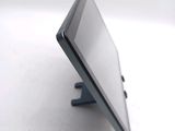 a tablet computer sitting on a stand on a white surface