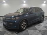 un SUV Volkswagen bleu garé sur un sol à damier dans un garage