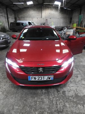 l'avant d'une voiture rouge dans un garage où se trouvent d'autres voitures